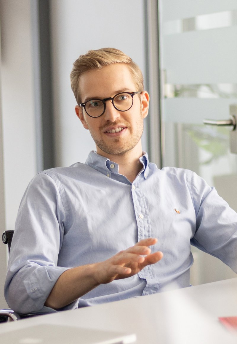 Christian Dauel gestikuliert freundlich im Konferenzraum